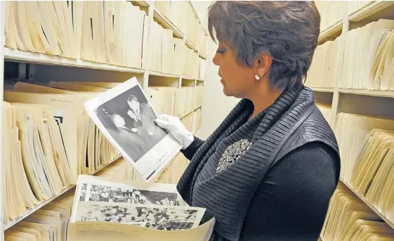  ??  ?? Linda Johnson Rice, chairman of Johnson Publishing, wears gloves to peruse photograph­s in Ebony’s archives. | BRIAN JACKSON~SUN-TIMES