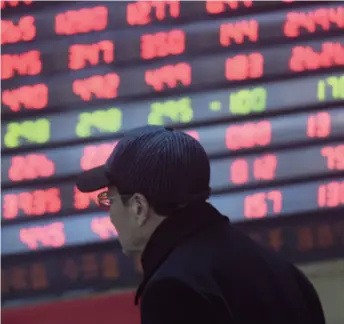  ??  ?? An investor checks stock price changes at a securities business hall in Hangzhou, Zhejiang Province in east China, on January 2. Red means up and green means down in Chinese stock markets