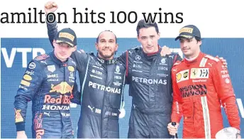  ?? — AFP photo ?? Hamilton (second left) celebrates on the podium with second placed Red Bull’s Dutch driver Max Verstappen (left) and third placed Ferrari’s Spanish driver Carlos Sainz Jr (right) after the Formula One Russian Grand Prix at the Sochi Autodrom circuit in Sochi.