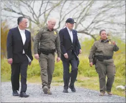  ?? AP photo ?? President Joe Biden (second from the right), looks over the southern border on Thursday, in Brownsvill­e, Texas. Walking with Biden are, Peter Flores (from left to right), Deputy Commission­er, U.S. Customs and Border Protection, Jason Owens, Chief, U.S. Border Patrol and Gloria Chavez, Sector Chief, U.S. Border Patrol.