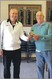  ??  ?? Roddy MacDonald presents the trophy to Ian Guy, winner of the gents’ singles on August 15.