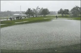  ?? The Associated Press ?? HAIL SHOCK: Hail covers the second green of the Pebble Beach Golf Links as a rules official looks on Sunday during the scheduled final round of the AT&amp;T Pebble Beach Pro-Am golf tournament in Pebble Beach, Calif.