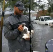  ?? ROBERT BUMSTED — THE ASSOCIATED PRESS ?? In this image from video, a resident holds a cat rescued by boat in floodwater­s in Jacksonvil­le, N.C., Friday.