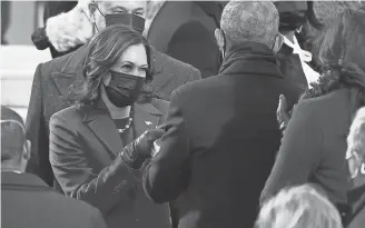  ??  ?? Harris gives a double fist-bump to former President Barack Obama on Wednesday before the ceremony. PHOTOS BY ROBERT DEUTSCH/USA TODAY