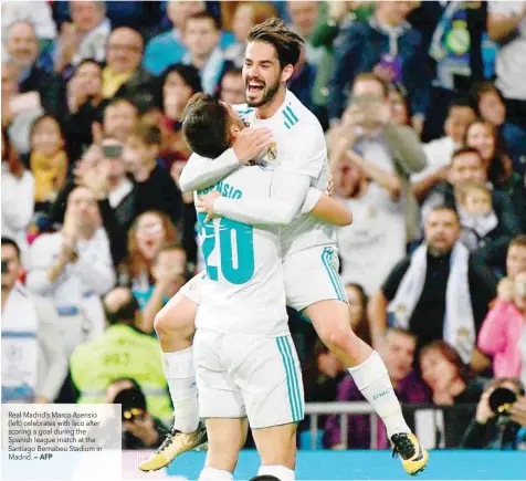  ?? — AFP ?? Real Madrid’s Marco Asensio (left) celebrates with Isco after scoring a goal during the Spanish league match at the Santiago Bernabeu Stadium in Madrid.