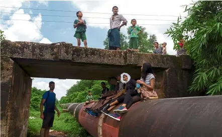  ?? — reuters ?? Pandemic pipe dream: Tourists taking part in a historic walking tour on the 85-year-old Myanmar pipeline to tackle boredom amid the lockdown in yangon.