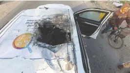  ?? REUTERS ?? A PALESTINIA­N MAN rides a bicycle past a damaged vehicle where employees from the World Central Kitchen (WCK), including foreigners, were killed in an Israeli airstrike in in Deir Al-Balah, in the central Gaza Strip, April 2.