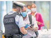  ?? FOTO: ROESSLER/DPA ?? Bundespoli­zisten kontrollie­rten am Flughafen in Frankfurt Passagiere eines Fluges aus Portugal. Das Land gilt als Virusvaria­ntengebiet. Einreisend­e müssen sich nach der Ankunft in Quarantäne begeben.