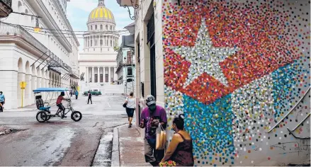  ?? YAMIL LAGE/GETTY-AFP ?? People go about their business one July day in Havana. Despite government censorship, many podcasts have found large groups of fans.