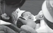  ?? NIU SHUPEI / FOR CHINA DAILY ?? A medical worker takes a sample from an infant for a nucleic acid test in Xuchang, Henan province, on Thursday.