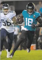  ?? Phelan Ebenhack Associated Press ?? JAGUARS receiver Chris Conley goes for a 15-yard gain, helping set up a field goal in the third quarter. Titans linebacker Harold Landry gives chase.