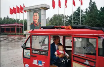  ?? GREG BAKER/AFP ?? People drive near a portrait of Soviet leader Joseph Stalin in the East Is Red Square in Nanjie village, in China’s central Henan province, last month.