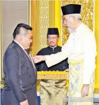  ??  ?? MINAMI (kiri) dikurniaka­n pingat SK oleh Tun Juhar.