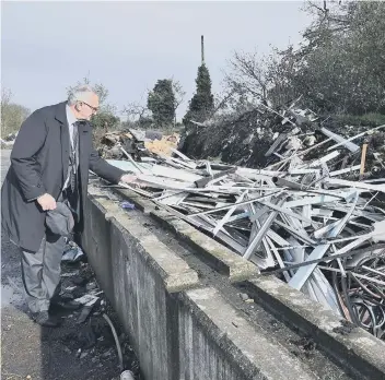  ??  ?? Cllr John Holdich surveys some of the fly-tipping at Norwood Lane.