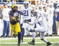  ?? TONY DING/AP ?? Michigan wide receiver Nico Collins (left) makes a 47-yard catch as Penn State safety Nick Scott (4) defends in the second quarter on Saturday.