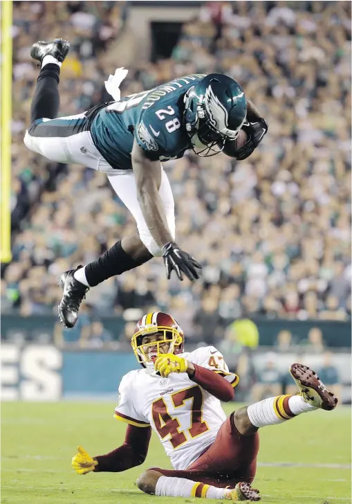  ?? — THE ASSOCIATED PRESS ?? Philadelph­ia Eagles running back Wendell Smallwood goes airborne to avoid a tackle by Washington Redskins cornerback Quinton Dunbar during the first half of Monday night’s game in Philadelph­ia.