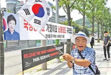  ??  ?? A supporter of Park shouts while waving a South Korean flag during a protest demanding her release outside the Seoul Central District Court. — AFP photo