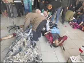  ?? AP photo ?? Palestinia­ns wounded in an Israeli strike while waiting for humanitari­an aid on the beach in Gaza City are treated in Shifa Hospital on Thursday.