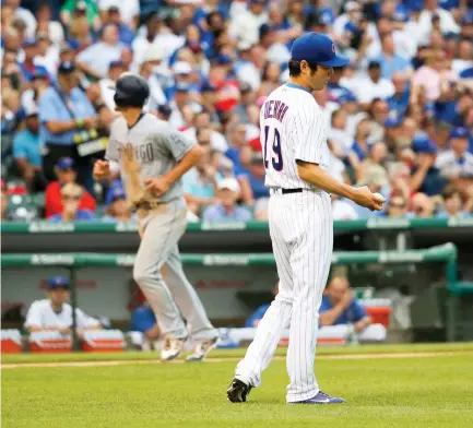  ??  ?? Chicago Cubs relief pitcher Koji Uehara, right, heads back to the mound after giving up a bases-loaded walk to San Diego Padres' Luis Torrens, scoring Wil Myers, background left, during the eighth inning of a baseball game Wednesday in Chicago. (AP)