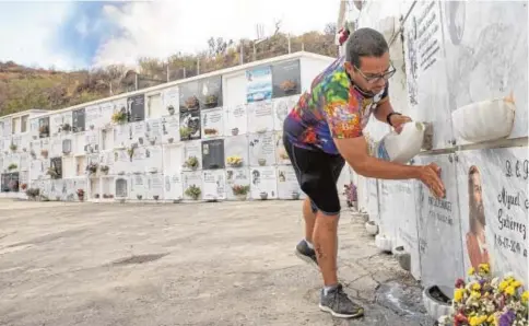  ?? // MANU NAVARRO ?? José Alejandro, empleado de la funeraria local, limpia una lápida del cementerio de Las Manchas