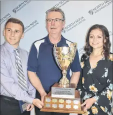  ?? FRAM DINSHAW/THE NEWS ?? Neil MacKinnon presents Alex Moore and Breanna Sandluck with the True Grit Award.