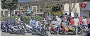  ??  ?? Scooter motorists queue for fuel outside a petrol station in Beirut