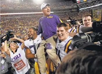  ?? CRYSTAL LOGIUDICE, USA TODAY SPORTS ?? Les Miles is picked up by his players Saturday after LSU beat Texas A&M 19-7. The Tigers head coach almost was fired.