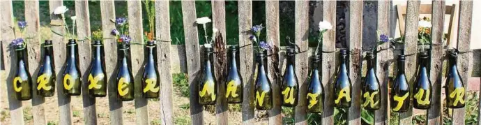  ??  ?? Originelle Flaschen-Einladung am Gartenzaun zum Besuch der Croxer Manufaktur in Grochwitz. Fotos (): Ilona Berger