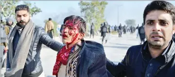  ??  ?? Pakistani plaincloth­es policemen arrest an injured activist (centre) during a clash in Islamabad. — AFP photo