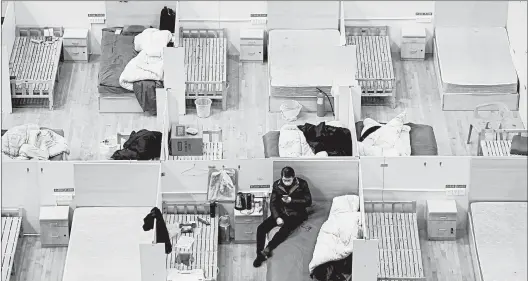  ?? GETTY-AFP ?? A patient rests at a temporary hospital set up for COVID-19 patients earlier this month at a sports stadium in Wuhan, the epicenter of China’s outbreak, in Hubei province.