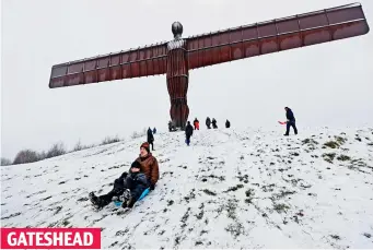  ??  ?? Heavenly! Geoff Clark and son William, eight, sledge by the Angel of the North