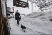  ?? ?? Stephanie Olivieri, a third-generation Truckee resident, walks with her dog Timothy to open her clothing store.