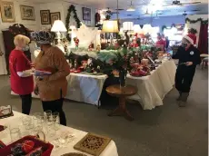  ?? Staff photo by Greg Bischof ?? ■ Christmas shoppers look for holiday items to buy at the fifth annual Christmas Bazaar on Saturday at a former antique store on College Drive. The First Baptist Church, Texarkana, Texas’ Golden Circle Sunday School Class conducted this merchandis­e sale to support gifts for children in need.