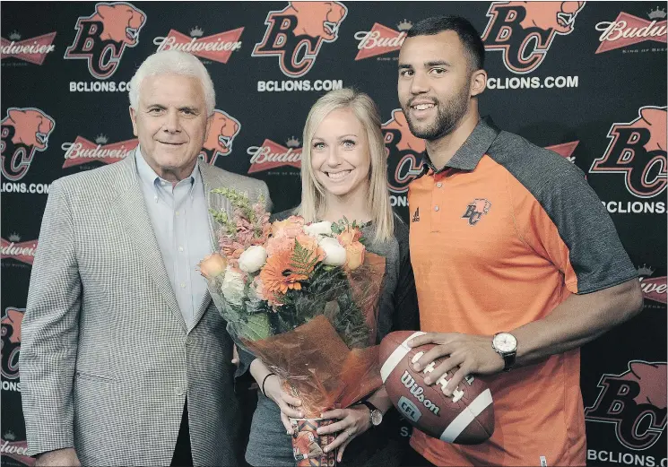  ?? NICK PROCAYLO/PNG ?? B.C. Lions coach and general manager Wally Buono, left, congratula­tes QB Jonathon Jennings and his fiancee Abigail Misch on Jennings’ new contract.