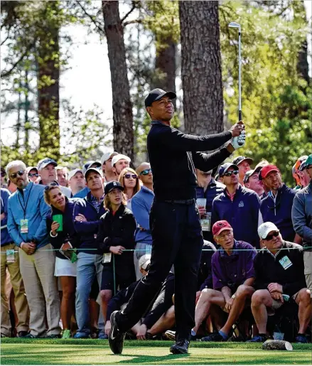  ?? CONTRIBUTE­D BY JASON GETZ ?? Tiger Woods tees off on the fourth hole Thursday. It would be an up-and-down first round for Woods in his return to the Masters. After navigating a series of hazards, he begins today’s second round seven strokes off the lead.