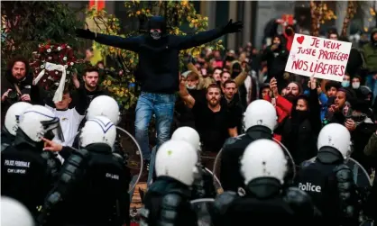  ?? Photograph: Stéphanie Lecocq/EPA ?? Protesters face riot police during a demonstrat­ion against Covid measures in Brussels this week.