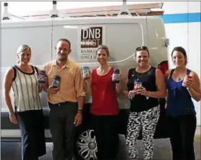  ?? SUBMITTED PHOTO ?? Several DNB First employees with some of the more than 1,500 pounds of peanut butter and jelly the company’s employees and customers donated during a three-week collection drive aimed at battling childhood hunger. The jars were donated to the Chester County Food Bank.