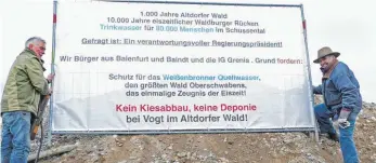  ?? FOTO: FRANZ KOHLER ?? Zwei Plakate drücken jetzt in Baienfurt Protest gegen den Kiesabbau im Altdorfer Wald aus. Eines steht am Ortseingan­g von Weingarten herkommend und eines am Kreisverke­hr Richtung Niederbieg­en. Auf dem Foto zu sehen sind Josef Sterk (links) und Klaus...