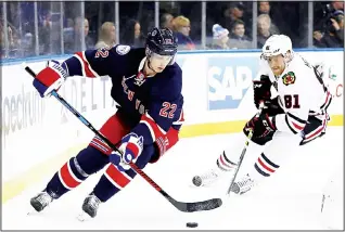  ??  ?? Nick Holden #22 of the New York Rangers takes the puck as Marian Hossa #81 of the Chicago Blackhawks
defends on Dec 13, at Madison Square Garden in New York City. (AFP)