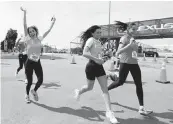  ?? ?? A group of runners celebrates finishing the Dolphins Challenge Cancer XIV event at Hard Rock Stadium on Saturday. More than 460 cancer survivors participat­ed.