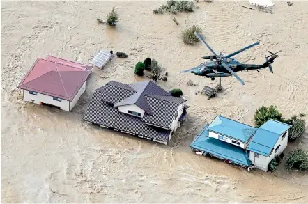  ?? AP ?? A Japan Self-Defence Force helicopter hovers above submerged residentia­l area after an embankment of the Chikuma River in Nagano, central Japan, broke because of Typhoon Hagibis.