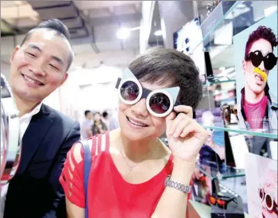  ?? CHEN XIAOGEN / FOR CHINA DAILY ?? A visitor tries on a stylish UV-light protective glasses at an internatio­nal optometric and optical fair in Beijing.