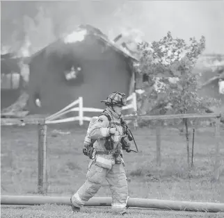  ?? JULIE OLIVER ?? The 2600 block of Prince of Wales was blocked off to traffic Friday afternoon after a fire broke out in a barn at Black Rapids Farm. Almost a dozen fire trucks were on scene to battle the massive blaze.