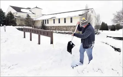  ?? Arnold Gold / Hearst Connecticu­t Media ?? Golf profession­al Joe DeGennero clears the snow from a walkway at the Race Brook County Club in Orange on Friday.