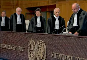  ?? AP ?? Presiding judge Ronny Abraham of France, right, enters to read the World Court’s verdict in the case brought by India against Pakistan in The Hague, Netherland­s, on Thursday. —