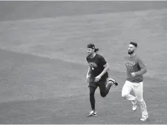  ?? AP Photo/Elise Amendola ?? ■ Boston Red Sox pitchers Joe Kelly, left, and Rick Porcello jog in the outfield during a workout Wednesday at Fenway Park in Boston. The Red Sox face the winner of the Oakland Athletics-New York Yankees wild-card game Friday in the American League Division Series.