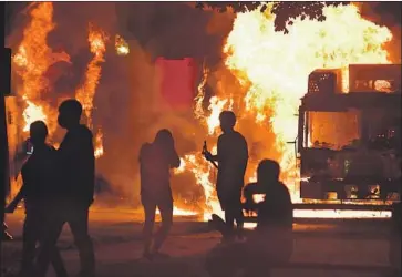  ?? Sean Krajacic Kenosha News ?? TRUCKS BURN near a courthouse Sunday night in Kenosha, Wis. Protesters clashed with officers after cellphone video showed police shooting Jacob Blake, a 29-year-old Black man, apparently in the back.