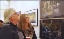  ??  ?? Ron Joyce, a photograph­er from Penticton, and his wife Joyce admire Rosemary Kean’s When Coal was King.