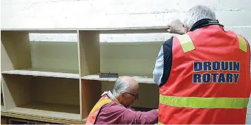  ??  ?? Roger Playdon and Maxwell Scott of Drouin Rotary Club install new shelving at Olivia’s Place.