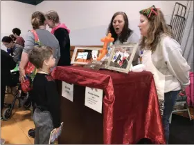  ?? ALEXIS OATMAN — THE NEWS-HERALD ?? Two volunteers help a child decide on a balloon animal on March 7.